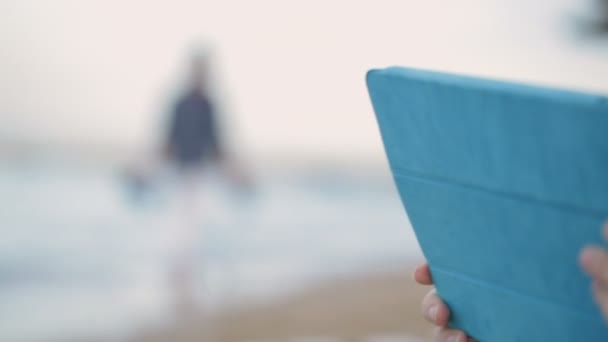 Garçon et mère utilisant pad sur la plage — Video