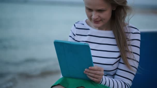 Mujer joven usando tableta PC por el mar — Vídeo de stock