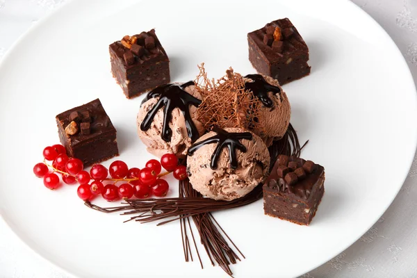 Chocolate ice cream with bonbons and red currants — Stock Photo, Image