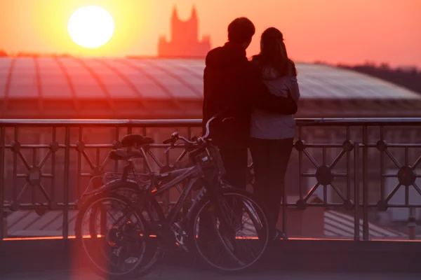 Пара насолоджується мальовничим заходом сонця в місті — стокове фото
