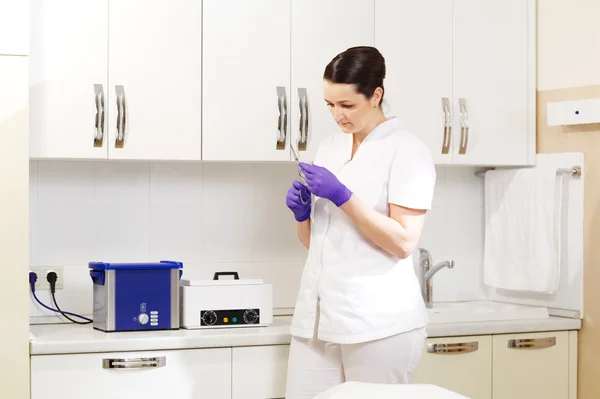 Kosmetikerin bereitet Werkzeuge für die Sterilisation vor — Stockfoto