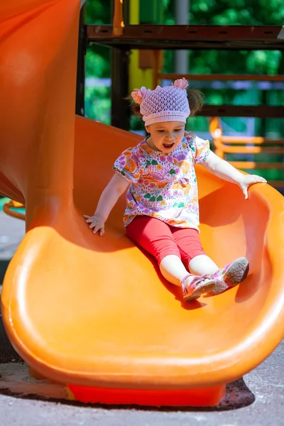 Menina pequena se divertindo em um slide — Fotografia de Stock