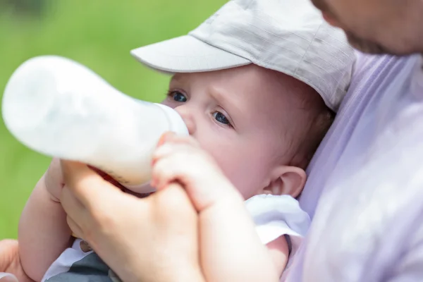 Человек кормит ребенка бутылкой — стоковое фото