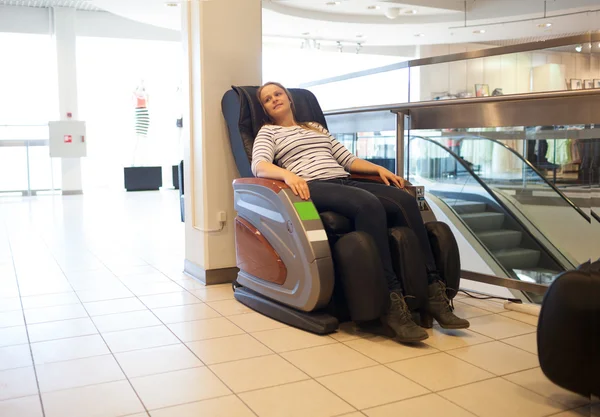 Mulher na cadeira de massagem no centro comercial — Fotografia de Stock
