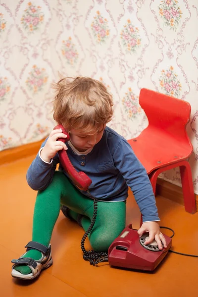Young boy using red phone — Stock Photo, Image