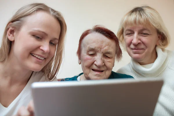 Drie vrouwen met behulp van een slimme tablet — Stockfoto