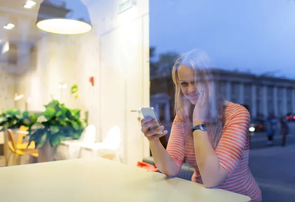 微笑的女士在咖啡馆阅读或键入短信 — 图库照片