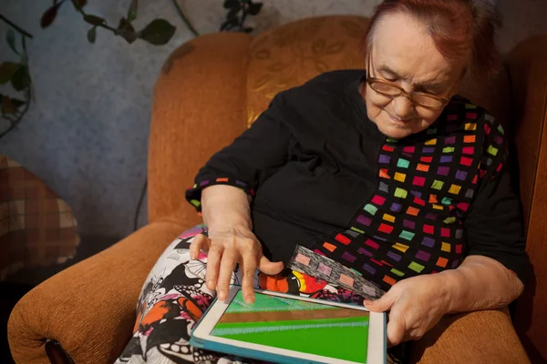 Donna anziana che naviga su Internet su un tablet — Foto Stock