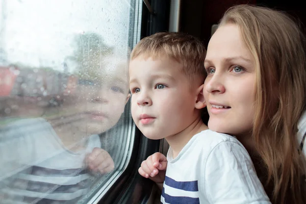 Mor och son som tittar genom en tågfönstret — Stockfoto