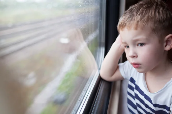 Boy looking out the window of train — Stock Photo, Image