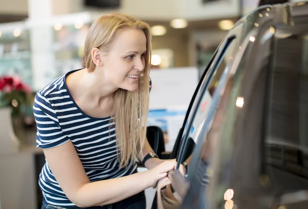 Femme admirant une voiture à un salon de l'auto — Photo