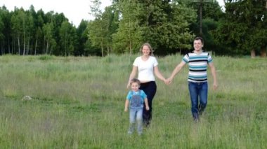 Anne, baba ve oğul çayır üzerinde yürüme