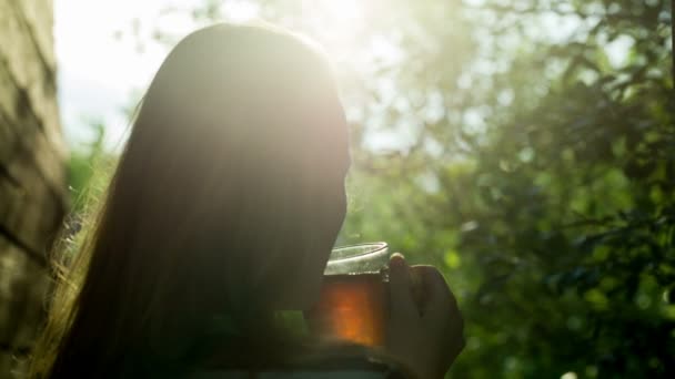 Meisje drinken van hete thee buiten bij zonsondergang — Stockvideo