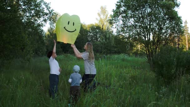 Mother with two sons flying smiling fire lantern — Stock Video