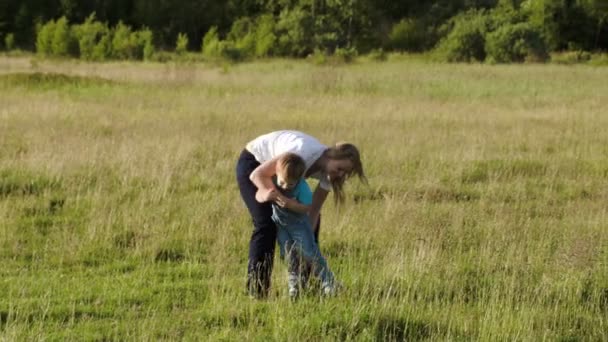 Joven madre jugando con su hijo al aire libre — Vídeos de Stock