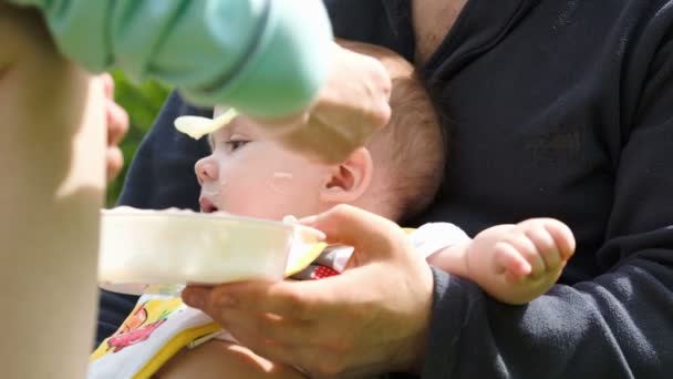 Mãe alimentando um bebê segurado pelo pai — Vídeo de Stock