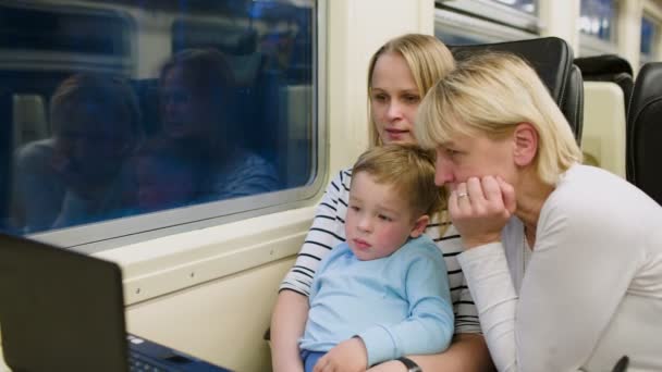 Семья в поезде смотрит видео на ноутбуке — стоковое видео