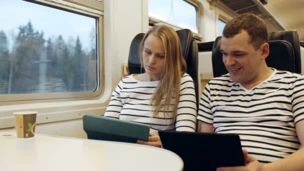 Giovani che parlano in treno guardando sul tablet pc — Video Stock