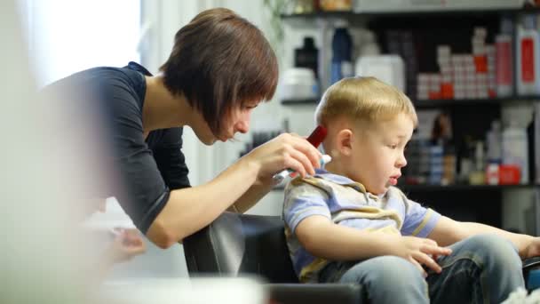 Little boy during haircut at the hairdressing saloon — Stock Video