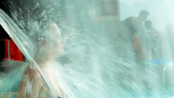 Woman refreshing under water shower in the pool — Stock Video