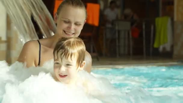 Moeder bedrijf zoon spetteren in het ruwe water van het zwembad — Stockvideo