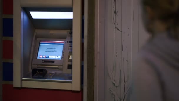 Vrouw invoegen bankkaart in atm om geld te krijgen — Stockvideo