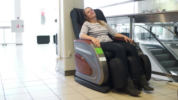 Женщина расслабляется в массажном кресле — стоковое видео