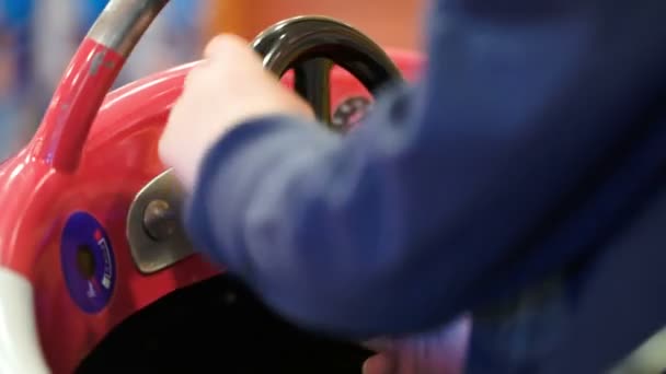 Kind dreht Lenkrad eines Spielzeugautos — Stockvideo