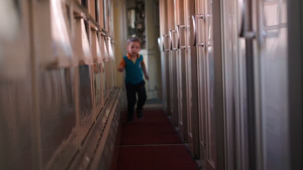 Happy boy running along the train hallway — Stock Video