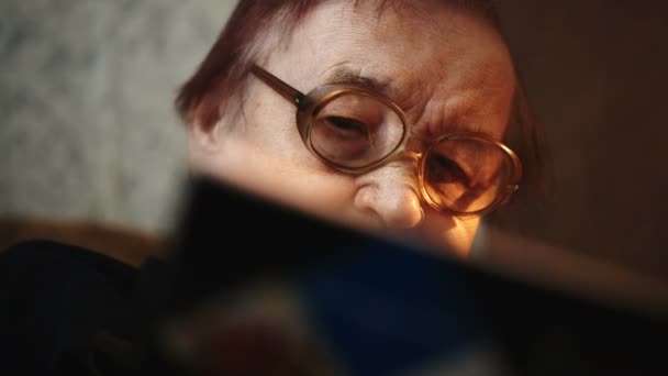 Äldre kvinna i glas med bok — Stockvideo