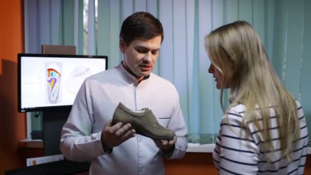 Médico dizendo mulher sobre sapatos vantagens — Vídeo de Stock