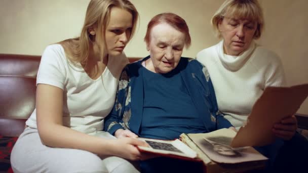 Vrouwen op zoek naar oude familiefoto 's — Stockvideo