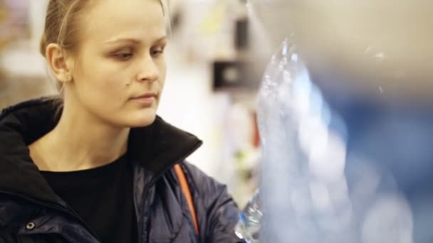 Femme choisissant une bouteille d'eau minérale — Video