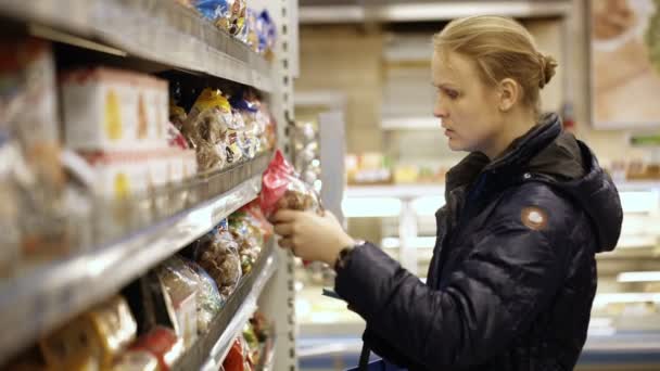 Женщина покупает продукты в продуктовом магазине — стоковое видео