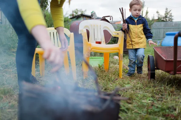 Mother and son making fire in the yard — Stock Photo, Image