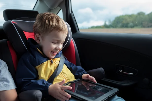 Rapaz feliz brincando com touchpad no carro — Fotografia de Stock