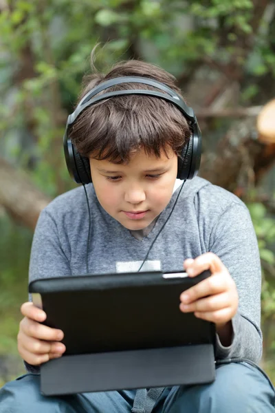 Teen boy in headphones with pad — Stock Photo, Image