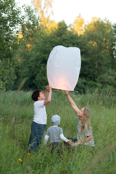 Family of three flying paper lantern outdoor — Stock Photo, Image