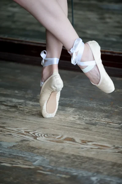 Dancing feet in ballet shoes on wooden floor — Stock Photo, Image