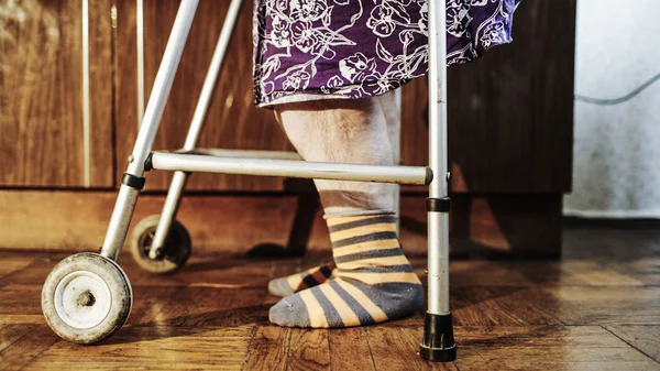 Yaşlı kadın walker yardımıyla yavaş yavaş gidiyor — Stock Fotó