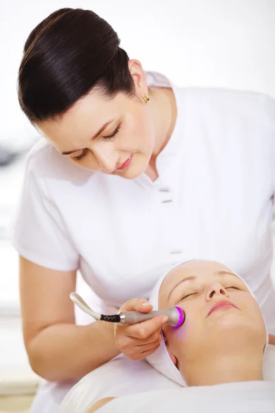 Cosmetician providing lifting procedure with special equipment — Stock Photo, Image