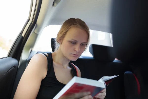 Woman reading a book in the car — Stock Photo, Image