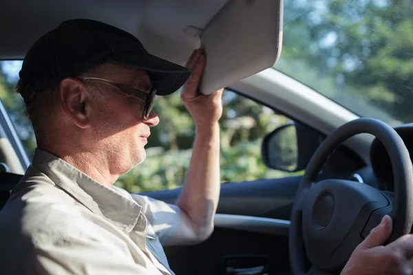 Senior-Fahrer versteckt sich vor der Sonne — Stockfoto