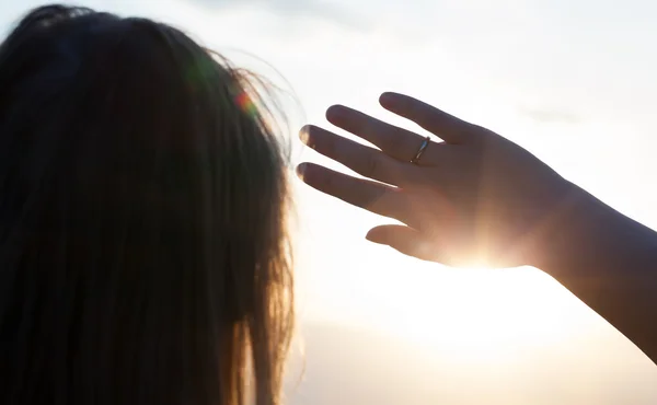 Frau versteckt sich mit Hand vor der Sonne — Stockfoto