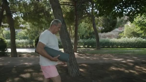 요가 매트를 들고 공원에 있는 사람 — 비디오