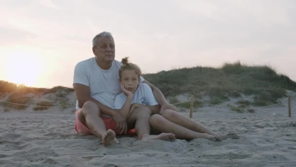 Abuelo y nieto en la playa al atardecer — Vídeo de stock
