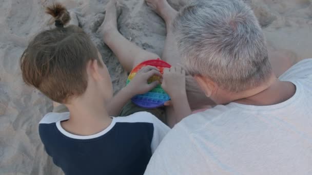 Kind betrekken opa in popit spelen — Stockvideo