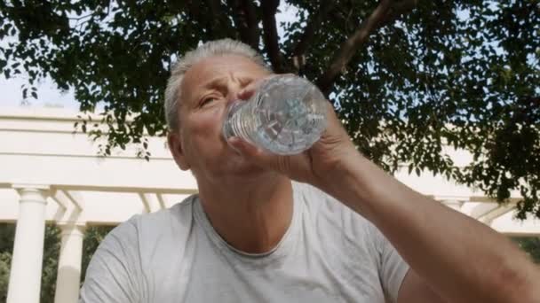 Sportowy biały mężczyzna pije wodę po zajęciach fitness — Wideo stockowe