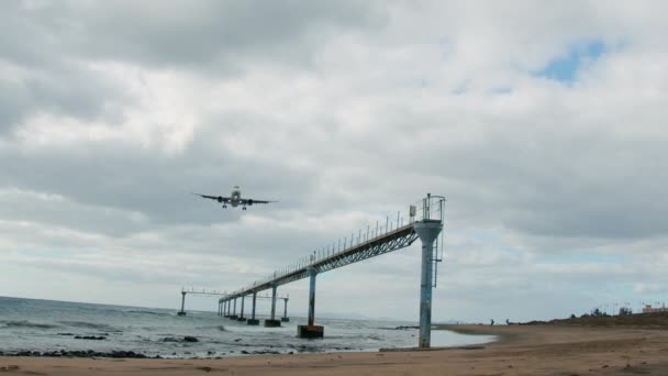 Низкоугольная Фронтальная Замедленная Съемка Посадки Самолета Над Морем Песчаного Пляжа — стоковое видео