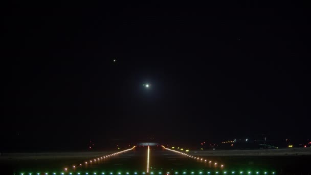 夜間空港滑走路に着陸する飛行機 — ストック動画